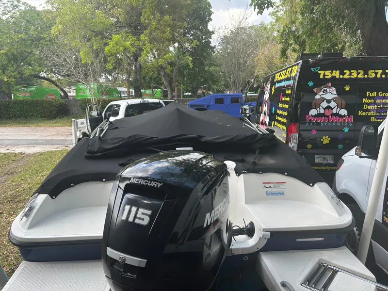 Slide: The Image of 2020 Bayliner Element boat with Mercury 115 engine, parked near pet grooming van. - 3