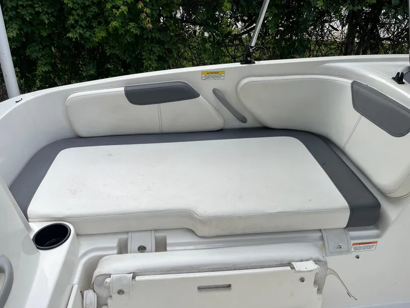 Slide: The Image of 2020 Bayliner Element boat interior seating with white and gray cushions. - 6