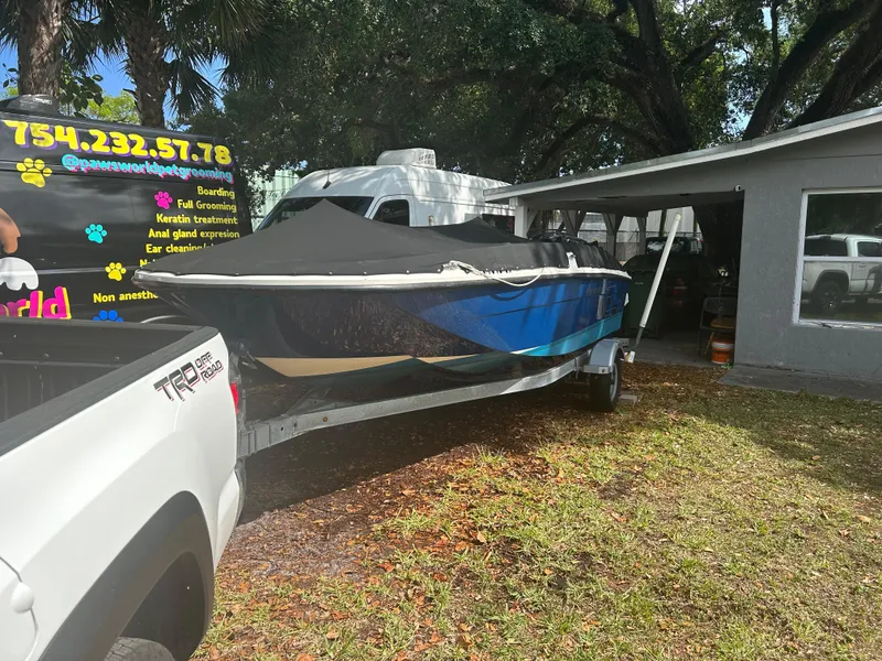 Slide: The Image of 2020 Bayliner Element boat on trailer, parked near pet grooming van and building. - 7