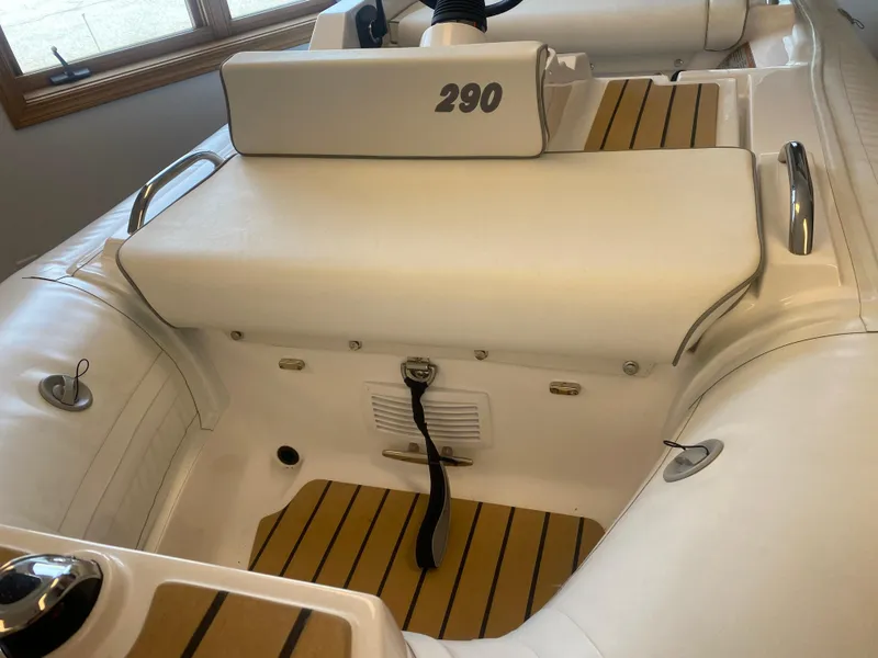 Slide: The Image of 2024 AB Inflatables ABJET 290 interior with white seating and teak-style flooring. - 3