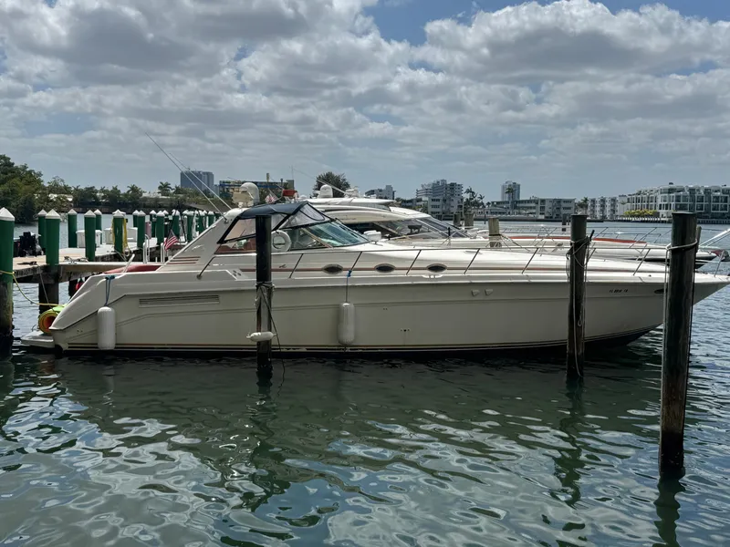 The Image of 1999 Sea Ray Sundancer 50 yacht docked at marina under cloudy sky. - 0