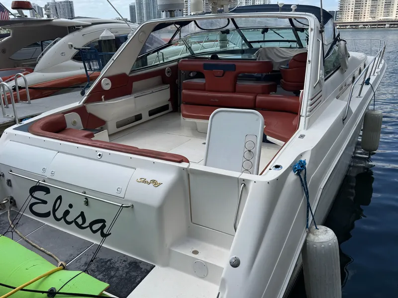 Slide: The Image of 1999 Sea Ray Sundancer 50 docked, featuring spacious deck and red seating. - 10