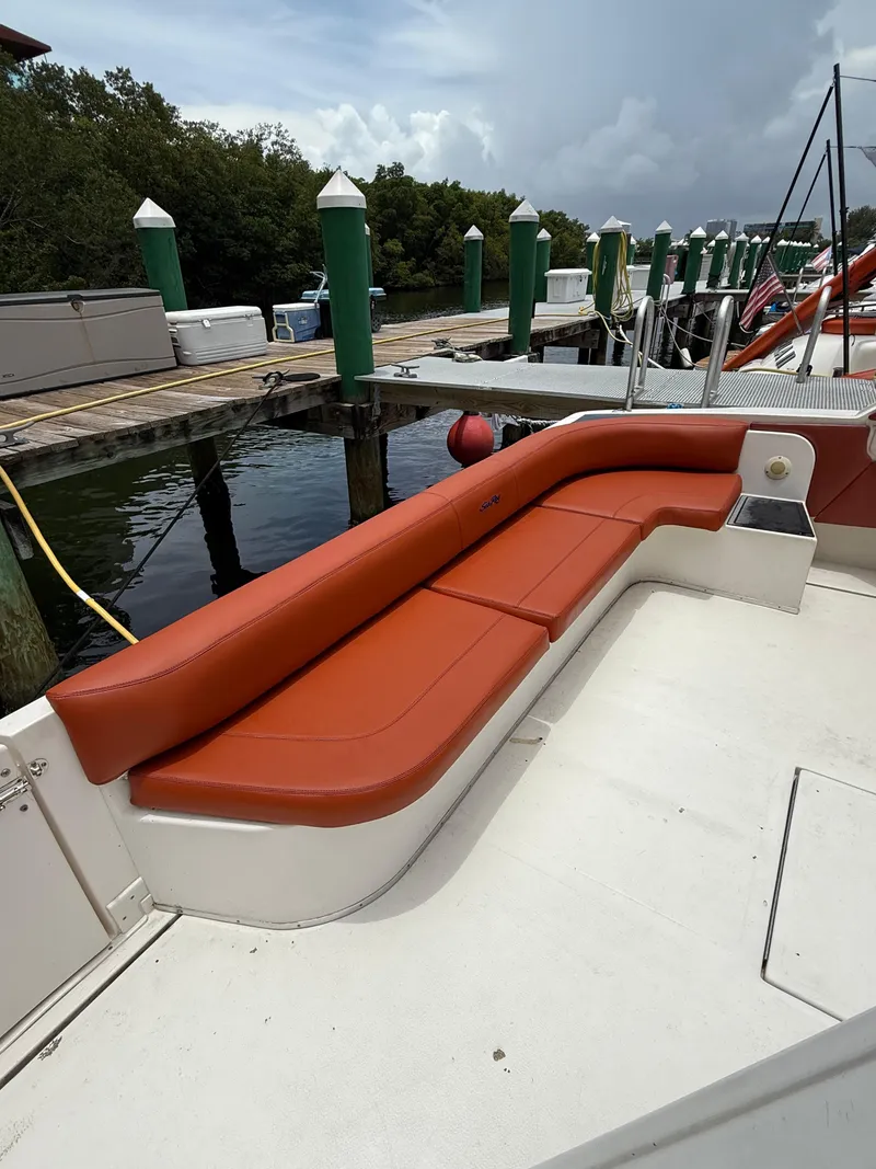 Slide: The Image of 1999 Sea Ray Sundancer 50 with red seating at a dockside location. - 12