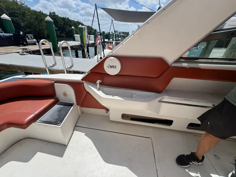 Slide: The Image of 1999 Sea Ray Sundancer 50 interior with red seating, docked at marina. - 13