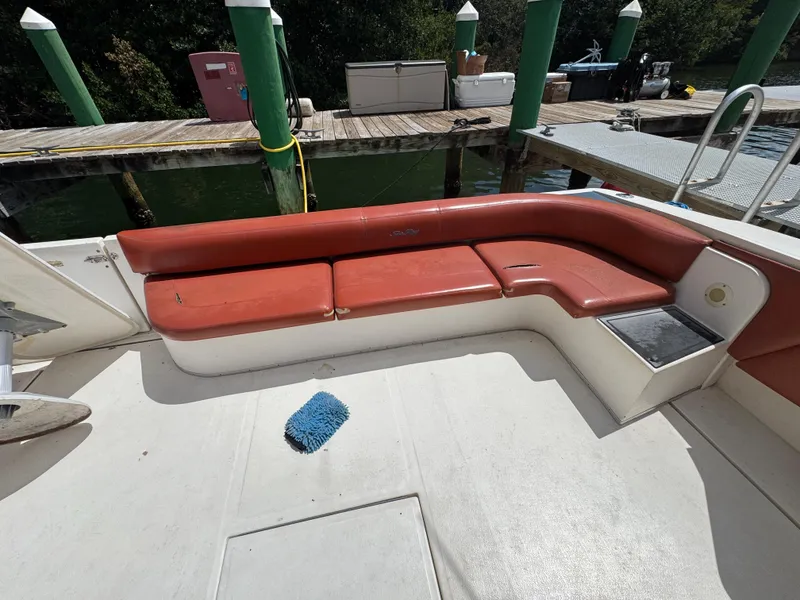 Slide: The Image of Red seating area on 1999 Sea Ray Sundancer 50 yacht, docked by green pilings. - 15
