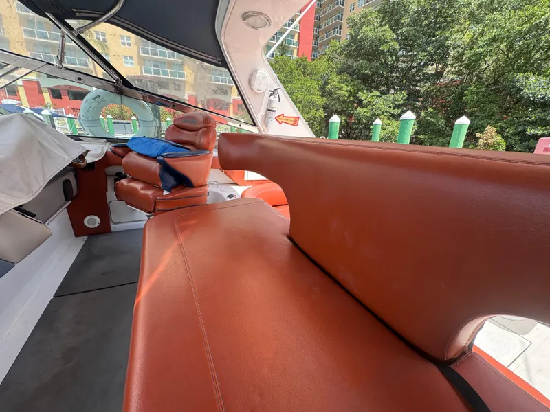 Slide: The Image of 1999 Sea Ray Sundancer 50 interior with brown leather seating and cityscape background. - 19