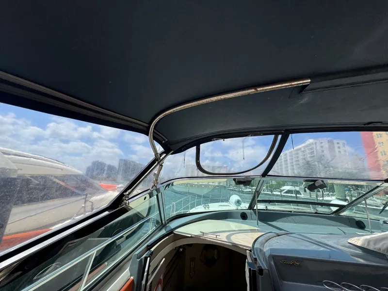 Slide: The Image of 1999 Sea Ray Sundancer 50 cockpit with canopy, marina view, clear skies. - 22