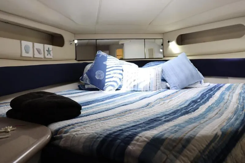 Slide: The Image of Cozy cabin interior of 1999 Sea Ray Sundancer 50 with striped bedding and nautical decor. - 25