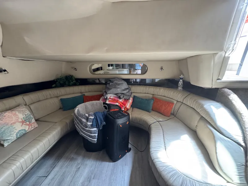 Slide: The Image of 1999 Sea Ray Sundancer 50 interior with curved seating, cushions, and luggage. - 27