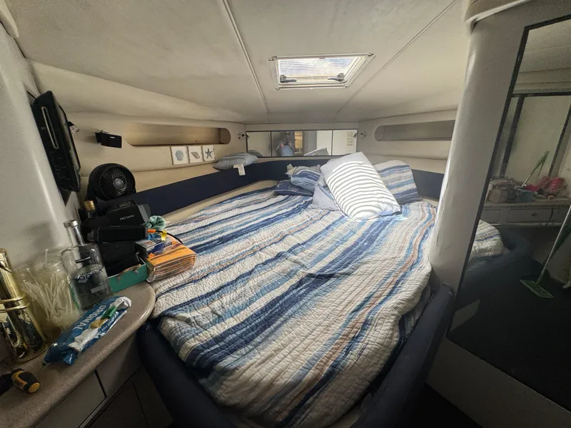 Slide: The Image of Cozy cabin interior of 1999 Sea Ray Sundancer 50 with striped bedding and nautical decor. - 28
