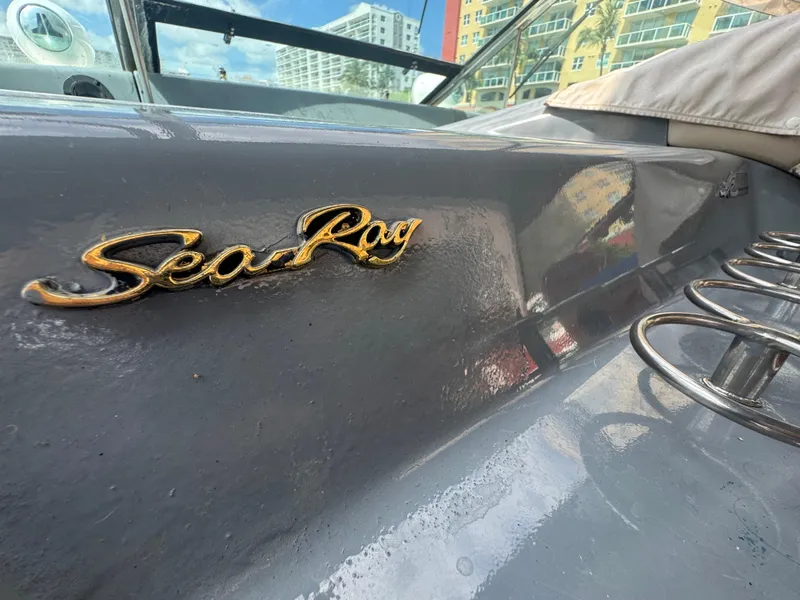 Slide: The Image of 1999 Sea Ray Sundancer 50 boat with logo, docked near modern buildings. - 33