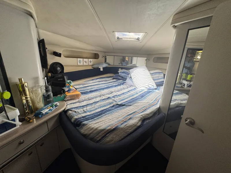 Slide: The Image of 1999 Sea Ray Sundancer 50 cabin interior with striped bedding and storage cabinets. - 45