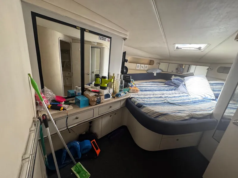 Slide: The Image of 1999 Sea Ray Sundancer 50 cabin interior with bed, mirror, and storage. - 46