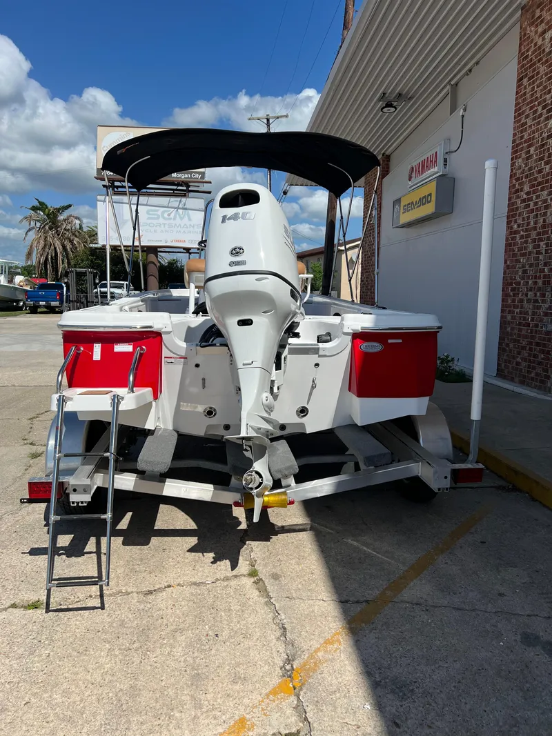 Slide: The Image of 2025 NauticStar 194 Bay boat on trailer, rear view, with outboard motor and ladder. - 2