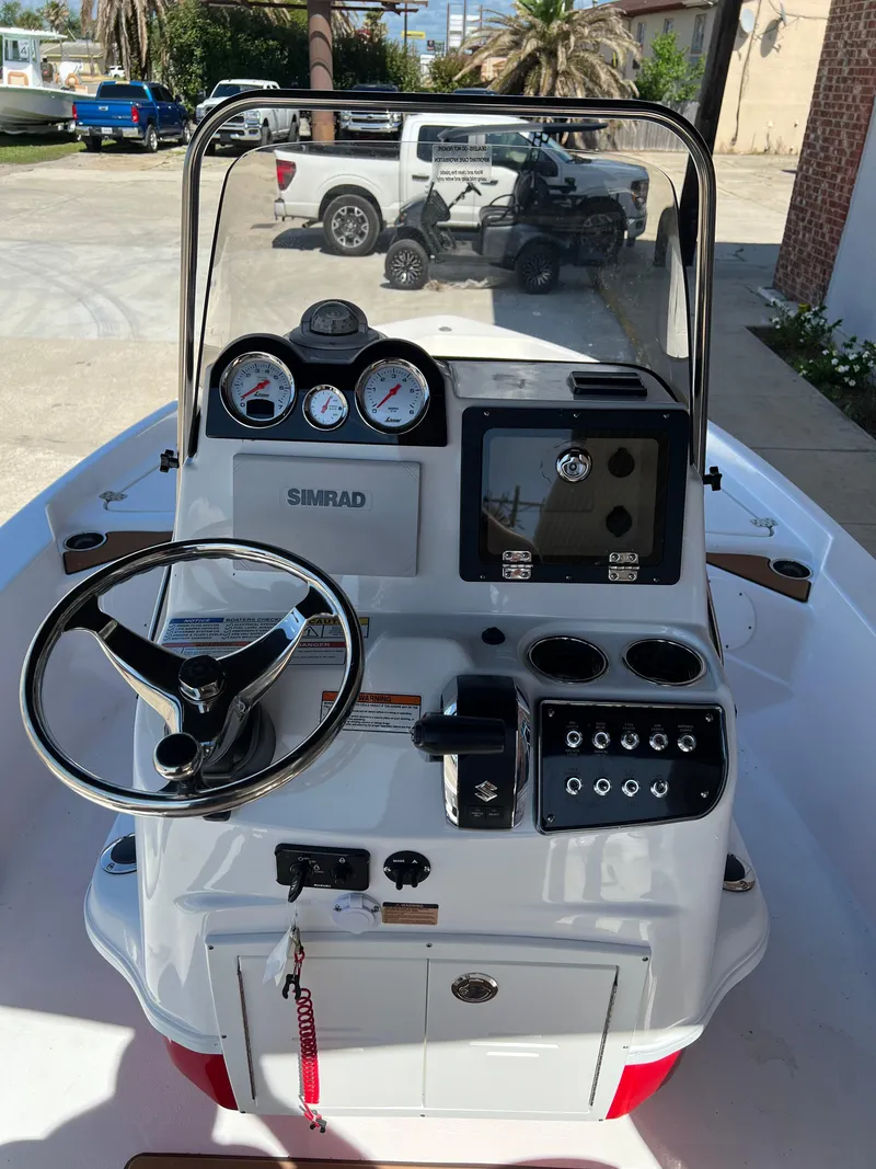 Slide: The Image of 2025 NauticStar 194 Bay boat dashboard with steering wheel and navigation controls. - 6