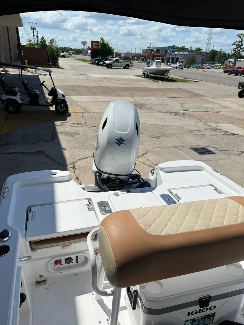 Slide: The Image of 2025 NauticStar 194 Bay boat with Suzuki outboard motor, parked outdoors. - 8