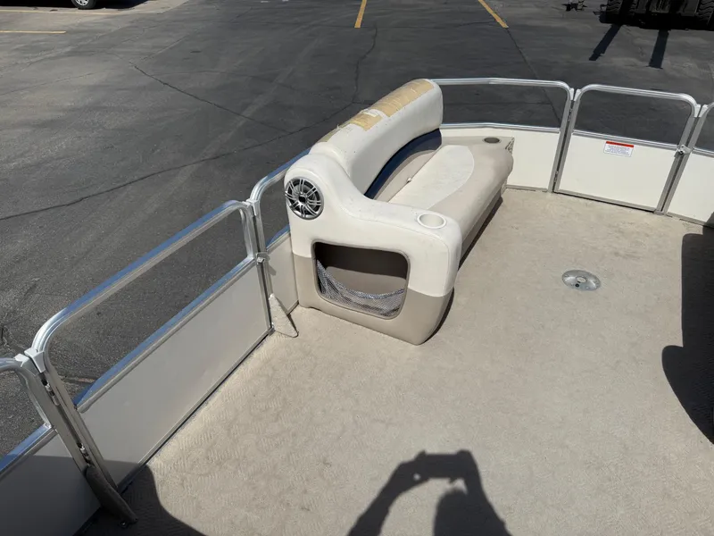 Slide: The Image of 2005 Sun Tracker Party Barge 21 interior with seating and speaker, parked on pavement. - 11