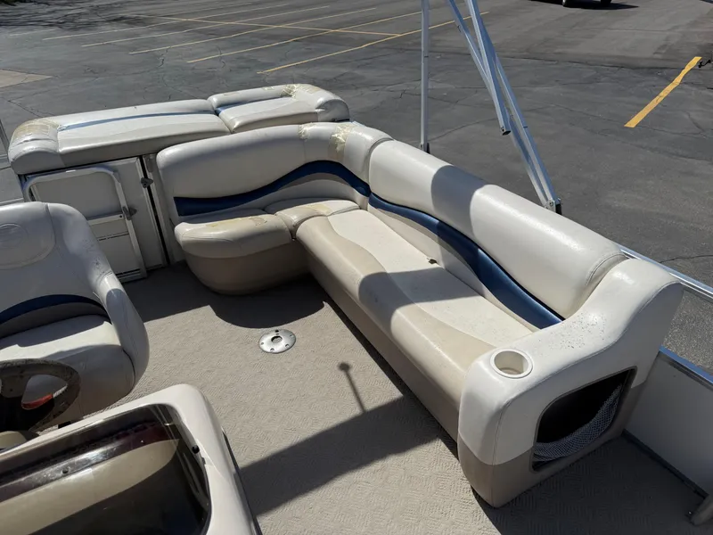 Slide: The Image of 2005 Sun Tracker Party Barge 21 interior with cushioned seating and storage compartments. - 15