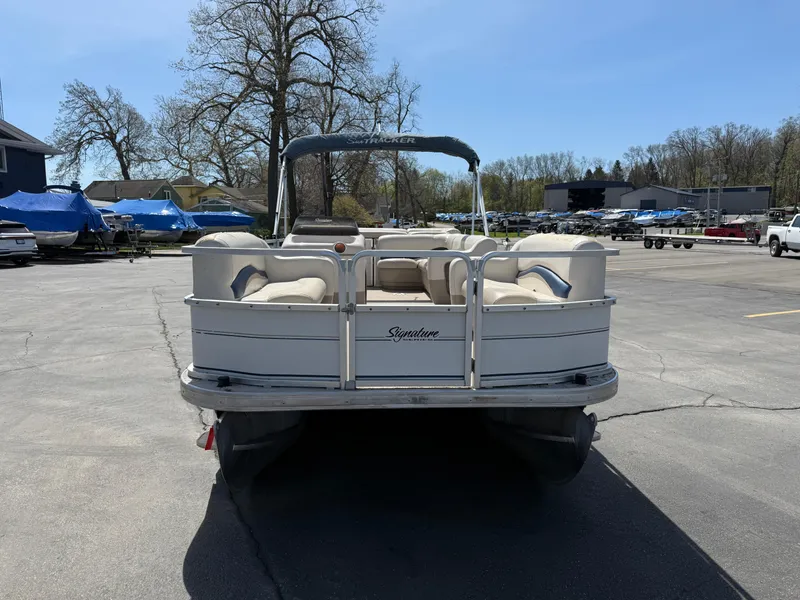 Slide: The Image of 2005 Sun Tracker Party Barge 21 pontoon boat parked in a lot, rear view. - 3