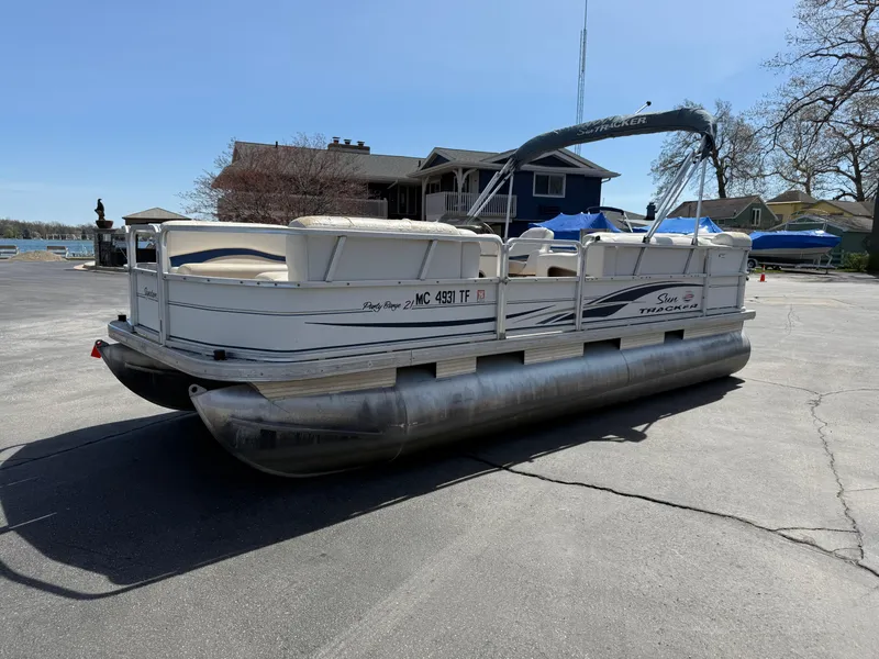 Slide: The Image of 2005 Sun Tracker Party Barge 21 pontoon boat parked on a driveway. - 4