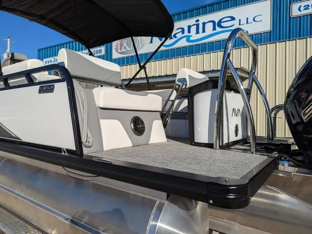 Slide: The Image of 2025 Avalon LSZ Quad Lounge Switch 2385 pontoon boat at dealership, featuring sleek design and seating. - 17