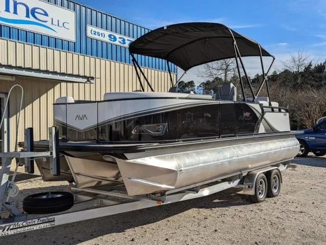 Slide: The Image of 2025 Avalon LSZ Quad Lounge Switch 2385 pontoon boat on trailer, parked outside dealership. - 4