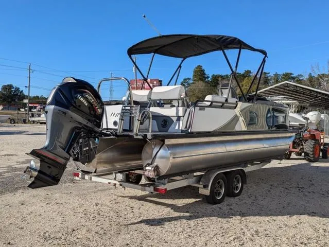 Slide: The Image of 2025 Avalon LSZ Quad Lounge Switch 2385 pontoon boat on trailer, outdoor display. - 8