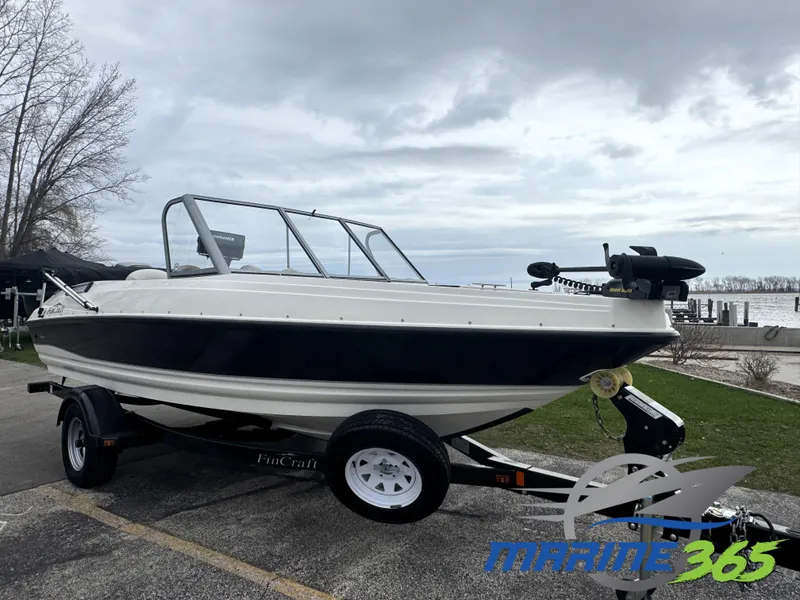 The Image of 2011 FinCraft 1850 boat on trailer, parked near a lake under cloudy skies. - 0