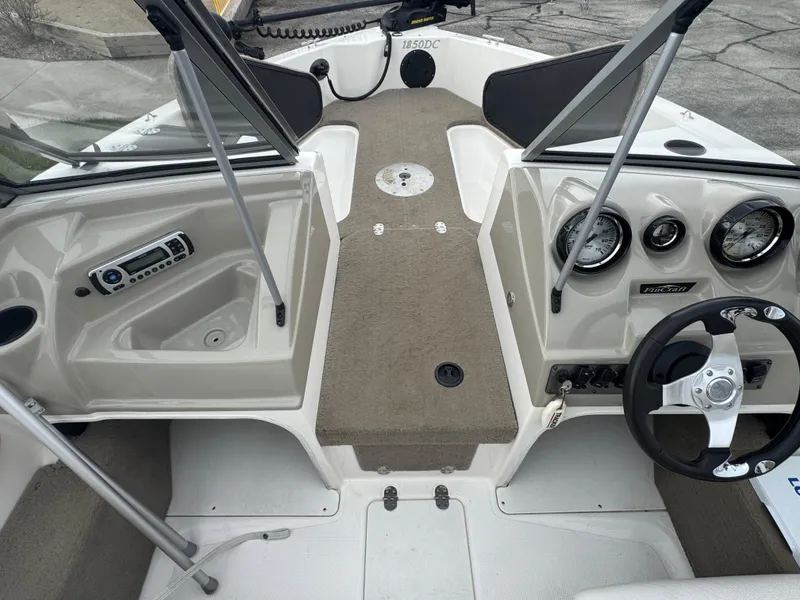 Slide: The Image of Interior view of a 2011 FinCraft 1850 boat, featuring steering wheel and dashboard controls. - 12