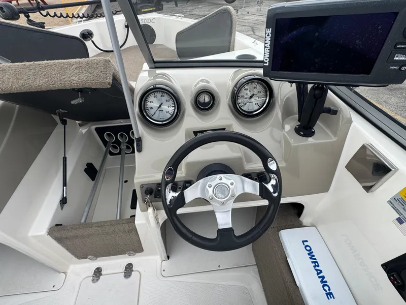 Slide: The Image of 2011 FinCraft 1850 boat dashboard with steering wheel, gauges, and Lowrance navigation system. - 14
