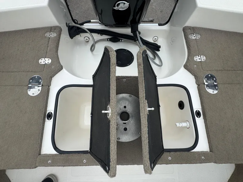 Slide: The Image of FinCraft 1850 boat interior storage compartments, 2011 model, featuring carpeted lids and metal hinges. - 16