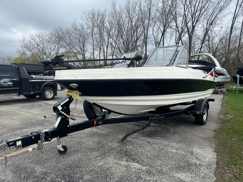 Slide: The Image of 2011 FinCraft 1850 boat on trailer, parked outdoors, with overcast sky and trees in background. - 3