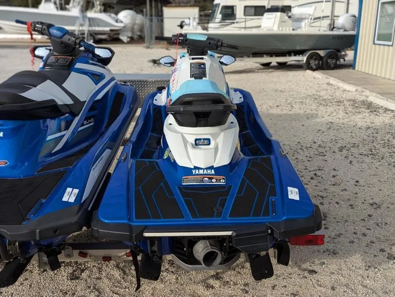 Slide: The Image of 2022 Yamaha WaveRunner EX LIMITED GP 1800 jet skis parked on gravel near boats. - 4