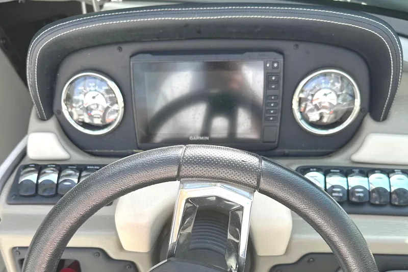 Slide: The Image of 2020 Crownline 290 SS boat on trailer, parked outdoors near trees and a house. - 37