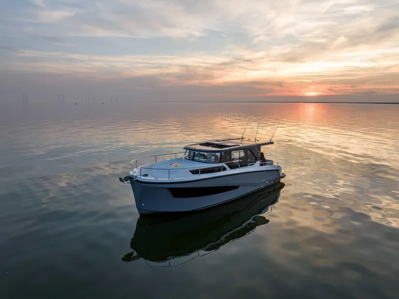 Slide: The Image of 2025 Delphia D10 Sedan yacht on calm water at sunset. - 1