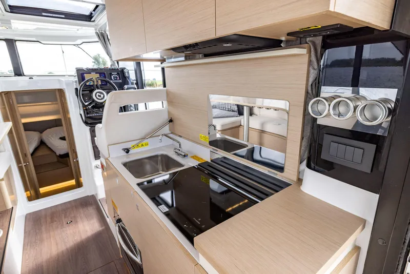 Slide: The Image of Modern kitchen interior of 2025 Delphia D10 Sedan yacht, featuring sleek appliances and wood finishes. - 11