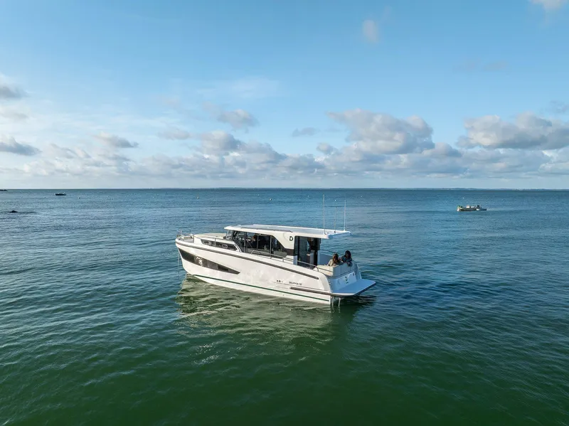 Slide: The Image of 2025 Delphia D10 Sedan boat cruising on calm ocean waters under a clear blue sky. - 2