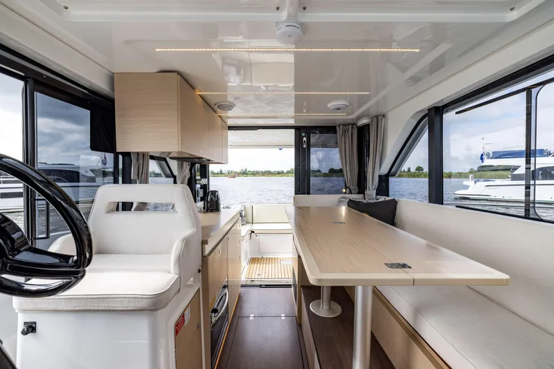 Slide: The Image of Interior of 2025 Delphia D10 Sedan boat with modern seating and dining area. - 9