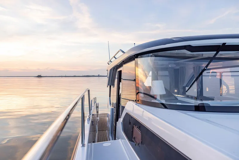 Slide: The Image of 2025 Delphia D10 Sedan yacht cruising on calm waters at sunset. - 5