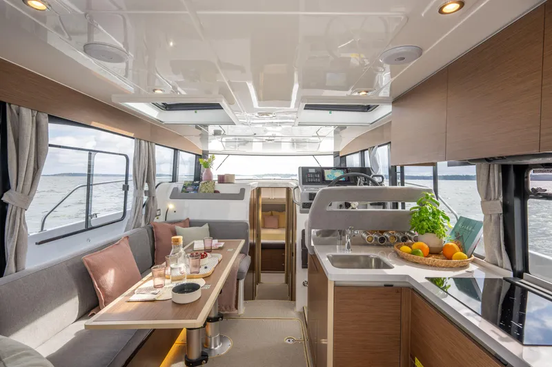 Slide: The Image of Interior of 2025 Delphia D11 SEDAN yacht, featuring modern kitchen and dining area with ocean view. - 5
