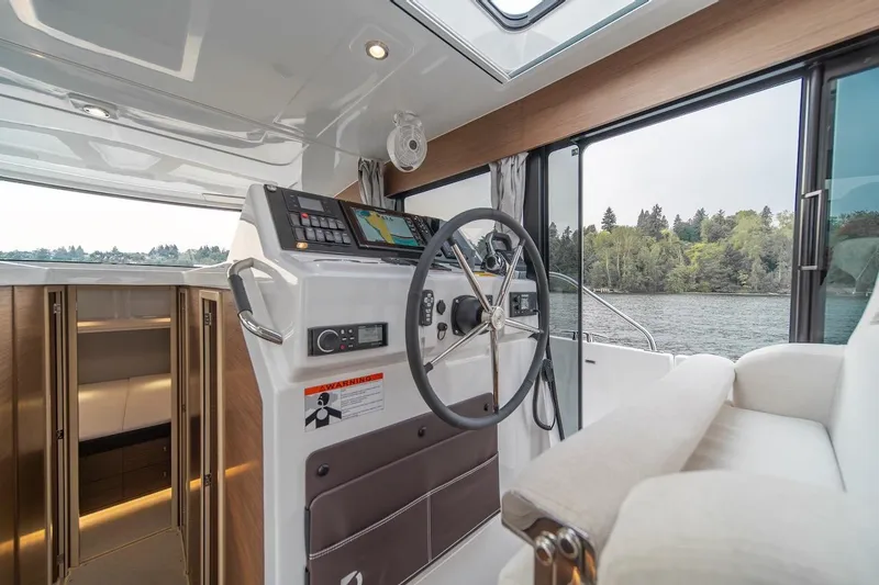 Slide: The Image of Interior of 2025 Delphia D11 SEDAN boat with modern helm and scenic water view. - 32