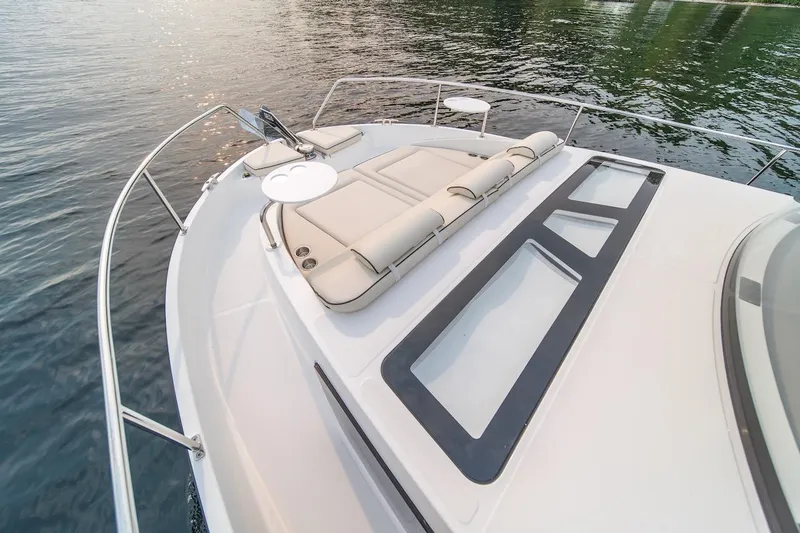 Slide: The Image of 2025 Delphia D11 SEDAN boat deck with sunbathing area and sleek design on water. - 13