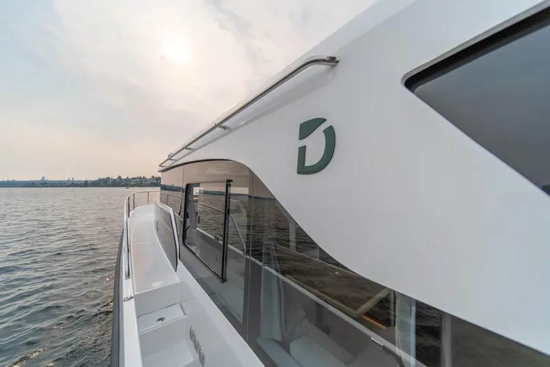 Slide: The Image of 2025 Delphia D11 SEDAN yacht cruising on calm waters under a cloudy sky. - 19