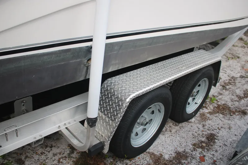 Slide: The Image of Trailer of a 2006 Seaswirl Striper 2601 boat with dual wheels on sandy ground. - 14