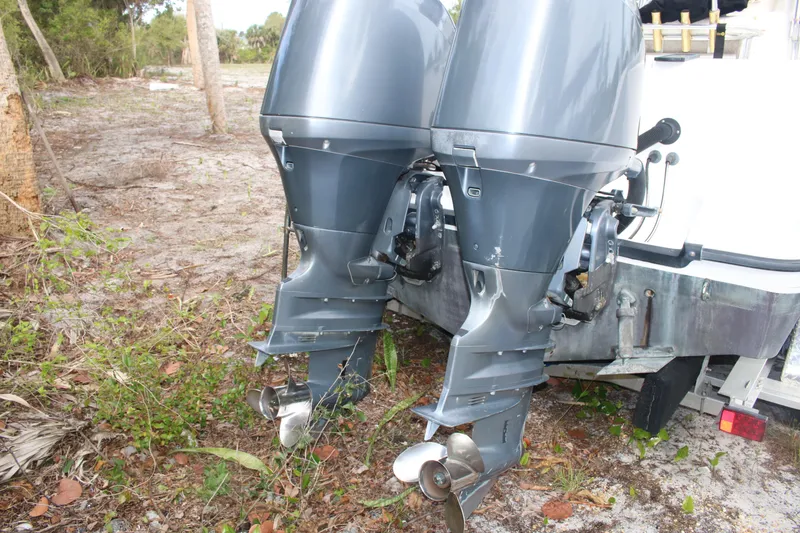 Slide: The Image of Twin outboard motors on a 2006 Seaswirl Striper 2601 boat, parked on a grassy area. - 16