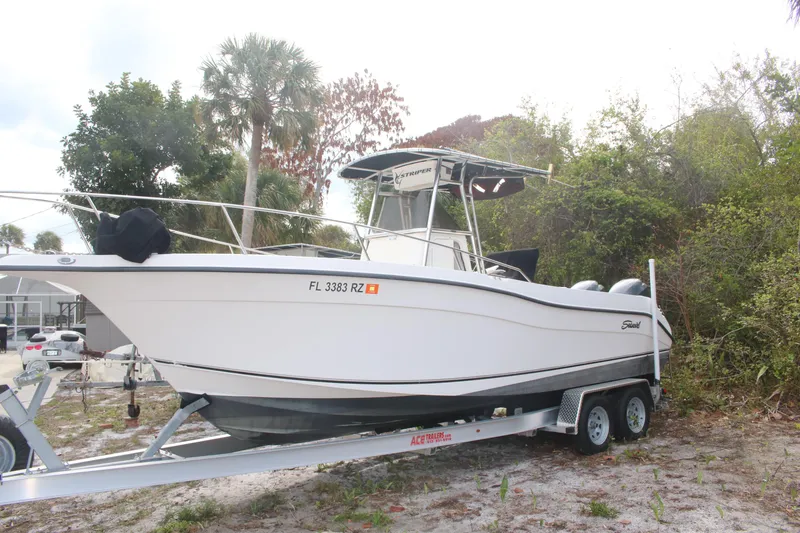 Slide: The Image of 2006 Seaswirl Striper 2601 boat on trailer, surrounded by trees and greenery. - 26