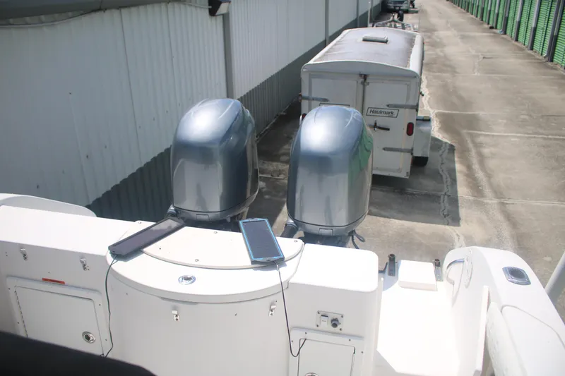 Slide: The Image of 2006 Seaswirl Striper 2601 boat with dual outboard motors, parked near a storage trailer. - 4