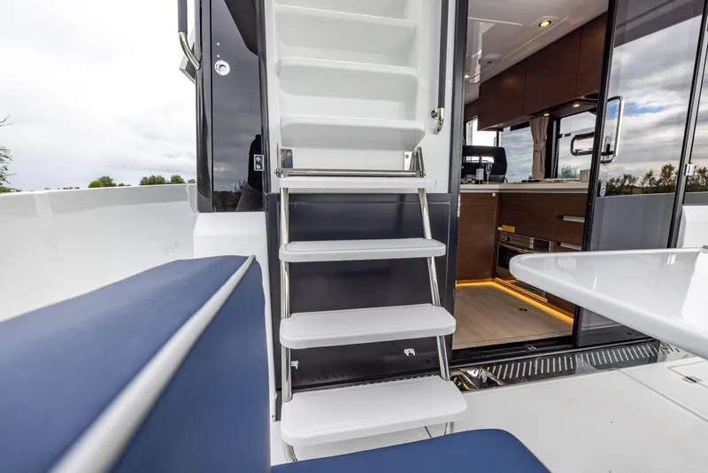 Slide: The Image of 2025 Delphia D11 Flybridge yacht interior with stairs and modern kitchen view. - 7