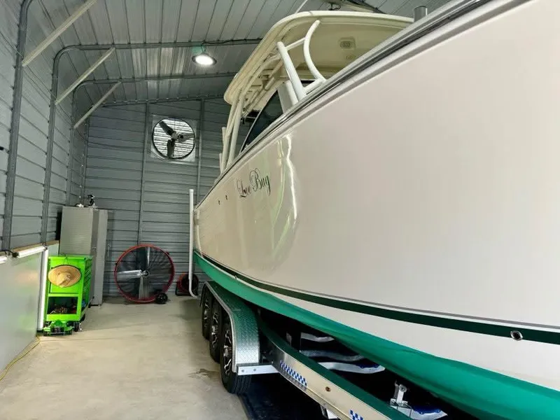 Slide: The Image of 2018 Sailfish 325 DC boat in storage, side view, inside a metal garage. - 15
