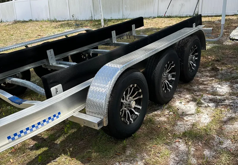 Slide: The Image of Triple-axle boat trailer for 2018 Sailfish 325 DC, parked on grass. - 20